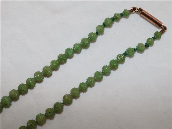 A Chinese carved jadeite bead necklace, early 20th century, total length 72.5cm, largest bead 9mm